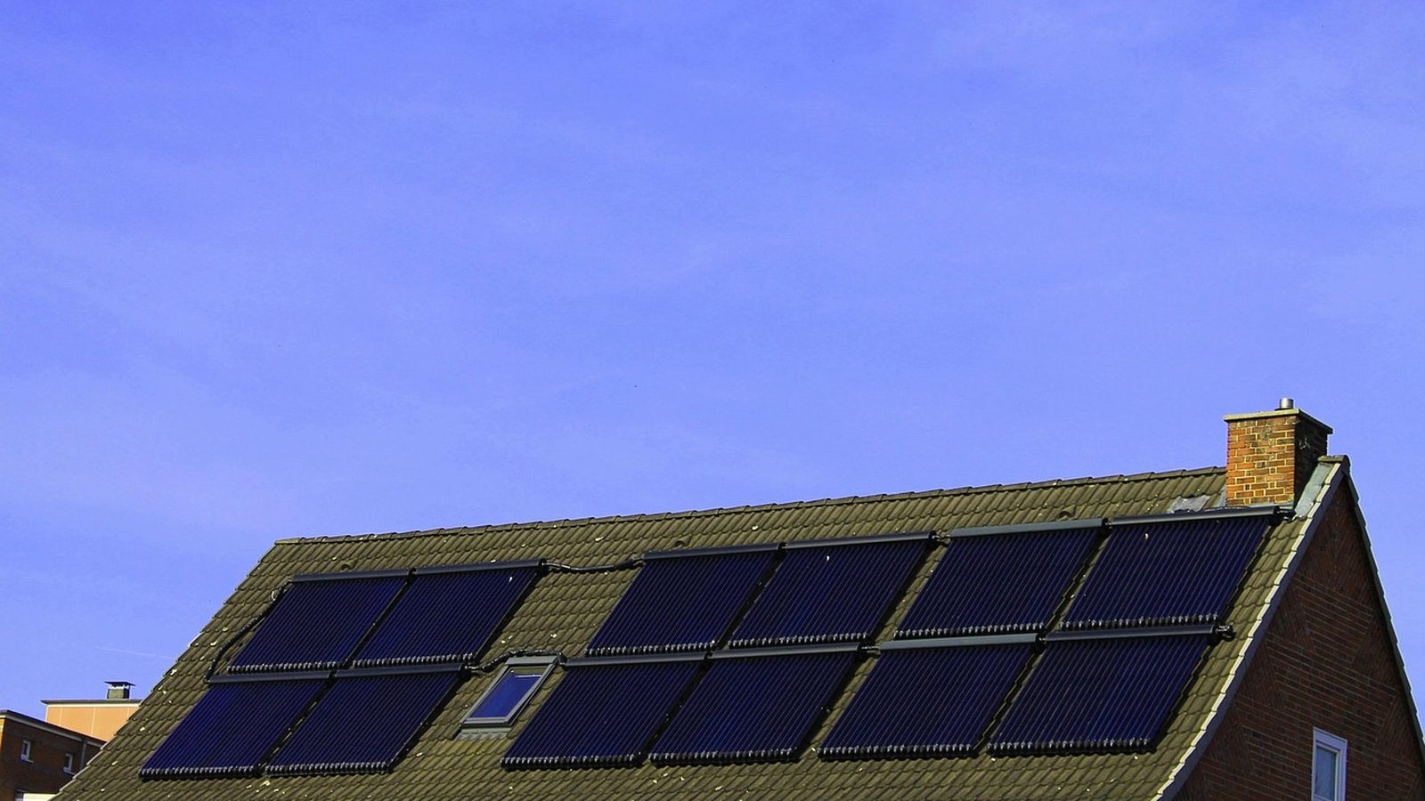 Rooftop solar panels on a house under a clear sky